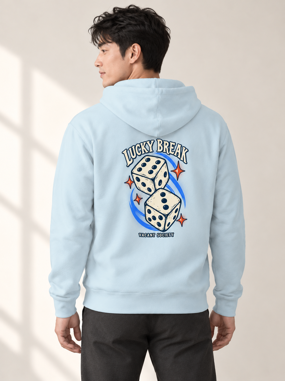 Adult model wearing the Lucky Break Hoodie in Sky Blue, showing the dice graphic on the back.